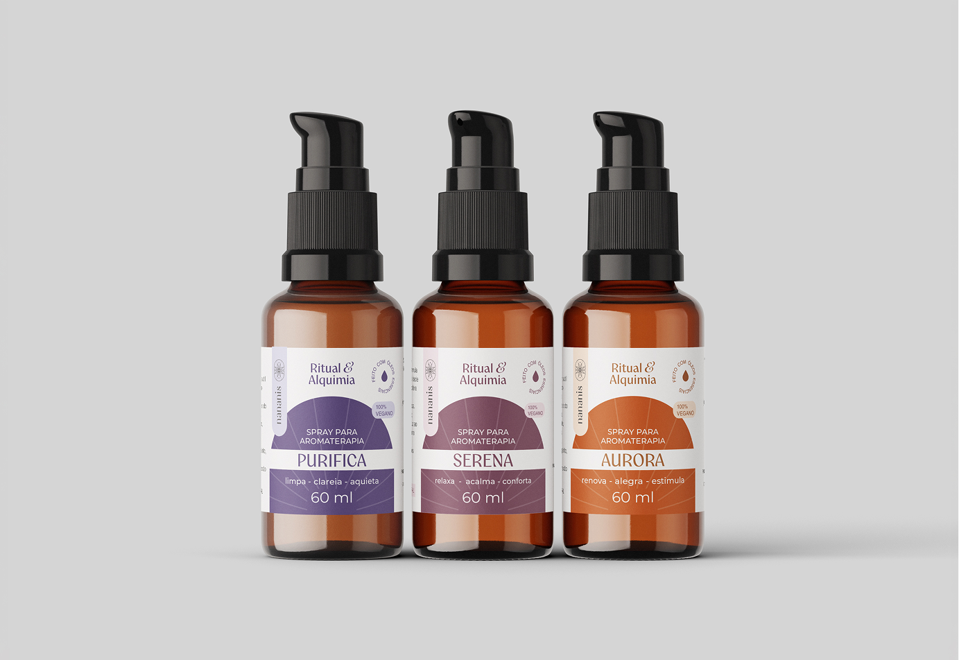 Imagem da linha de cosméticos "ritual de alquia" criado para a marca de aromateratia Nananis. A imagem mostra 3 produtos da linha com rótulos de cores diferentes em frasco ambar.
